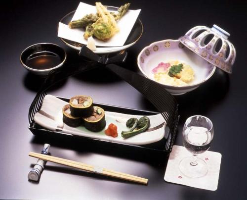 a table with plates of food and a glass of wine at Yudanaka Yasuragi in Yamanouchi
