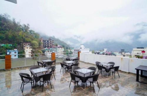 a group of tables and chairs on a balcony at The Shore Travelista in Rishīkesh