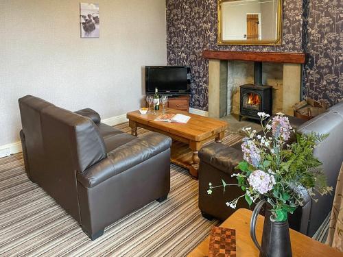 a living room with two couches and a fireplace at Bondcroft Farm Cottage in Embsay