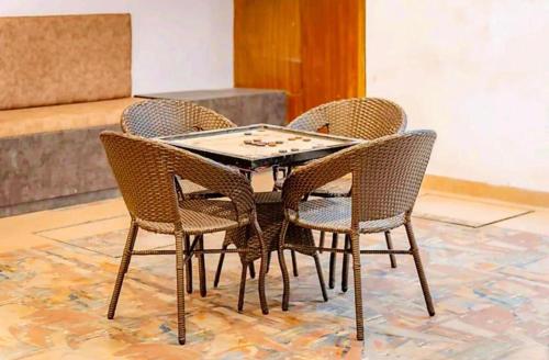 a table with four wicker chairs and a chessboard on it at The Shore Travelista in Rishīkesh