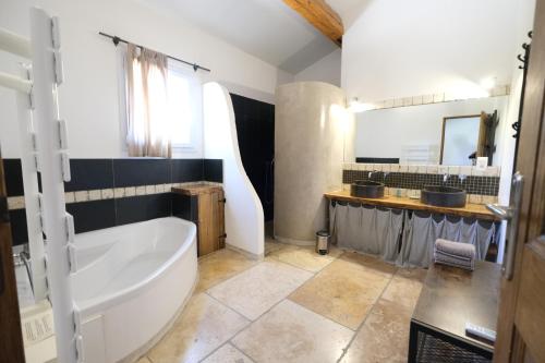 a large bathroom with a tub and a sink at nice villa with heated swimming pool, in the center of the village of aureille, 8 persons, near baux de provence, in the alpilles in Aureille