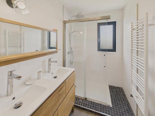 une salle de bain avec une douche, un lavabo et un miroir dans l'établissement Charmante maison pour 5 au coeur de Penmarch, à Penmarcʼh