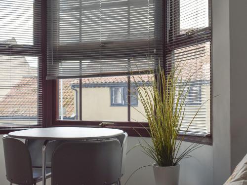 a table and two chairs in front of a window at High Street Apartment in Kessingland