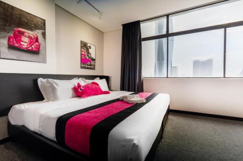 a bedroom with a bed with a pink stuffed animal on it at MagTree Chinatown in Kuala Lumpur