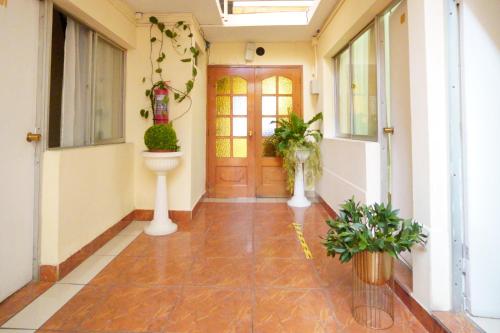 an empty hallway with a door and plants in it at Hotel Frontera in Antofagasta
