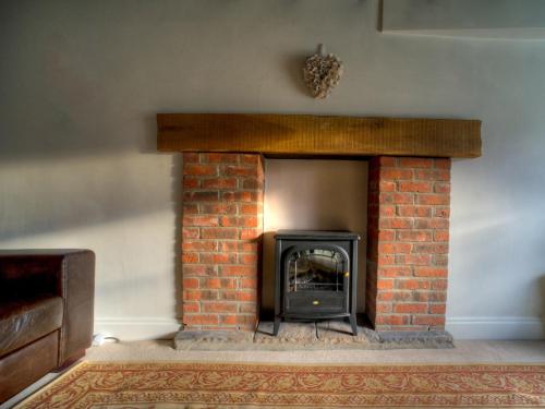 a brick fireplace with a fire place at Kings Head Cottage in Pickering