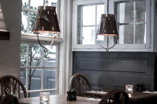 a dining room with tables and chairs and windows at Hotel Bella Italia in Sønderborg