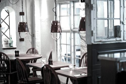 two tables and chairs in a restaurant with windows at Hotel Bella Italia in Sønderborg