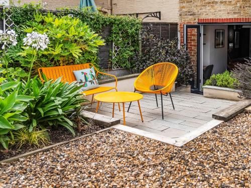 two chairs and a table on a patio at Eaton Beach House in Margate