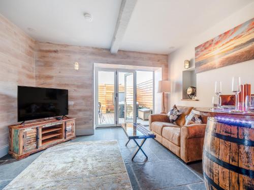 ein Wohnzimmer mit Couch und Flachbildfernseher in der Unterkunft The Drunken Carpenter's Cottage in Sneaton