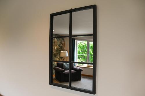 a mirror with a black frame on a wall at Aurora - Self Catering, Kirkwall, Quiet Location with Luxury Hot Tub in Orkney