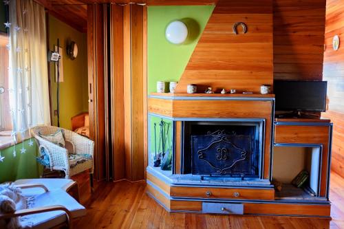 un soggiorno con camino e TV di Casa in centro storico stile chalet di montagna a Ovindoli