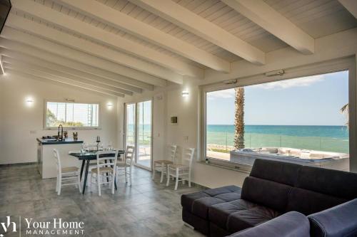 a living room with a couch and a table at Il Geranio - Resort & Suites in Acquedolci