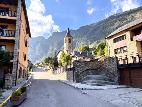 an empty street with a building and a church at Espot Cowork & Apartments - L'Amfitriona in Espot