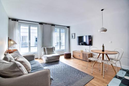 un salon avec un canapé, une table et des chaises dans l'établissement PARISIAN HOME l MONTORGUEIL, à Paris