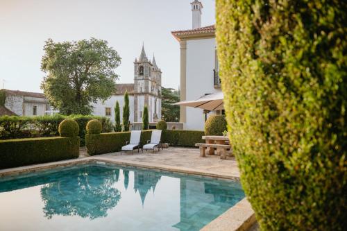 a swimming pool in front of a building at Quinta do Bonfim in Portalegre