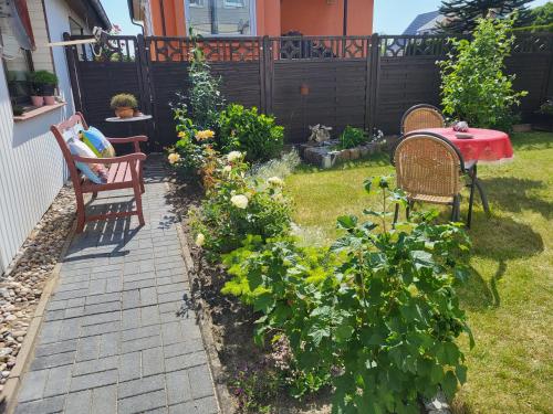 un jardín con mesa, sillas y plantas en FH Sabine, en Ribnitz-Damgarten