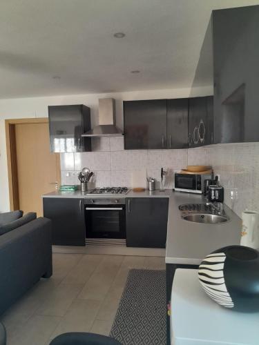 a kitchen with stainless steel appliances and black cabinets at Casas da Vila in Vila de Rei