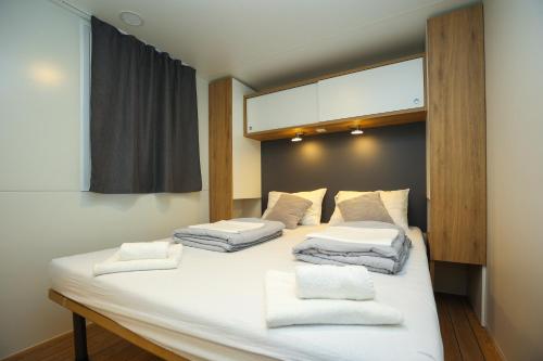 a large white bed with four pillows on it at Mobile homes Bepo in Sveti Filip i Jakov