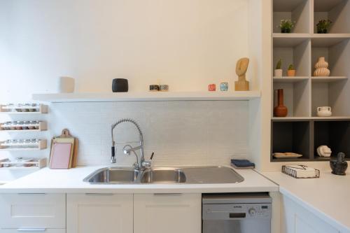 a white kitchen with a sink and shelves at Dimora - A Spacious Luxury Penthouse in Town's Heart in Corfu Town