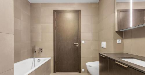 Un baño con inodoro, lavabo y puerta. en Stylish stay in downtown Rvk, en Reikiavik