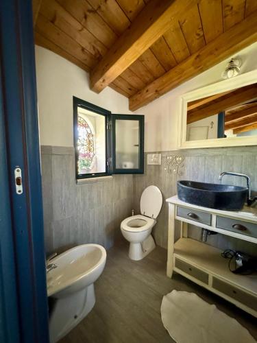 a bathroom with a sink and a toilet and a mirror at Villa Giulia in Parghelia