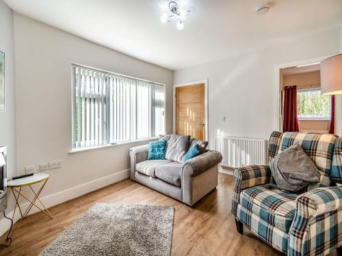 a living room with a couch and a chair at Riviera Cottages in Sewerby