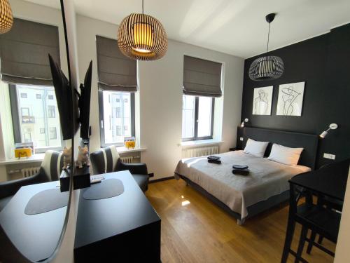 a bedroom with a bed and a desk in it at Albert Studio in Art Nouveau building with AC Top location near old town in Rīga
