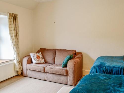 a living room with a couch and a bed at The Moorings in Lochmaben