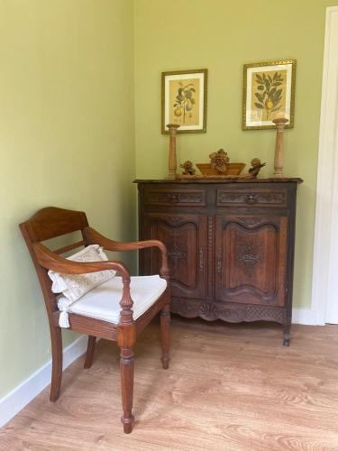 a chair and a wooden cabinet in a room at Gite Coccinelle in the medieval town of Confolens in Confolens