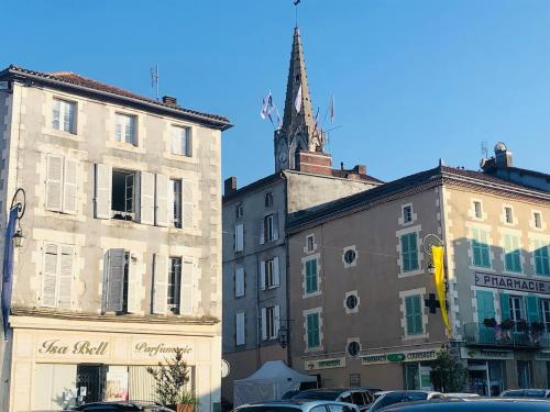 a group of buildings with cars parked in a parking lot at Gite Coccinelle in the medieval town of Confolens in Confolens