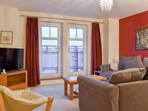 a living room with a couch and two windows at The Retreat in Whitby