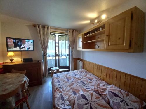 une chambre avec un lit, un bureau et une fenêtre dans l'établissement Bel appartement Samoens La Cour classe 2 etoiles, à Samoëns