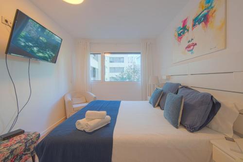 Un dormitorio con una cama con un televisor en la pared. en Benfica Prime Terrace II by Homing, en Lisboa