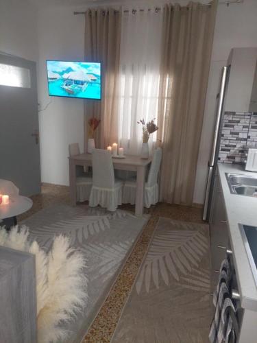 a living room with a table and a tv on the wall at Abi Central Home in Korissia