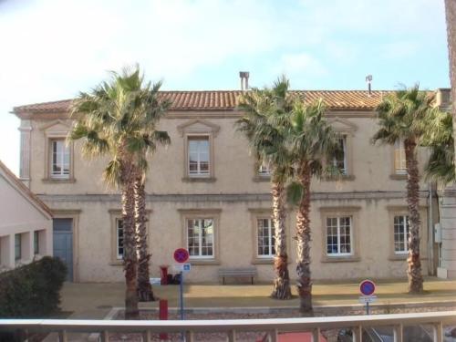 グリュイッサンにあるAu cœur du village de Gruissanの建物前のヤシの木群