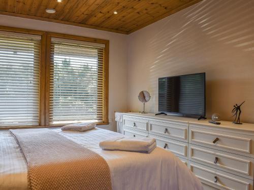 a bedroom with a bed and a flat screen tv at Madison in Jacobstow