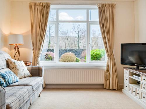 a living room with a couch and a large window at Parkfield in Keswick
