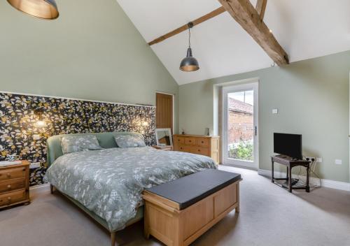 une chambre avec un grand lit et une fenêtre dans l'établissement Iken Barn, à Neatishead