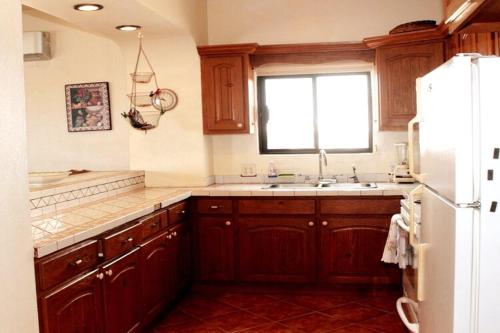 a kitchen with wooden cabinets and a sink and a window at The House of Angels in Las Conchas