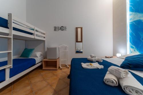a room with two beds and a bunk bed at "L'Oasi di Favignana" Room and Charme in Favignana