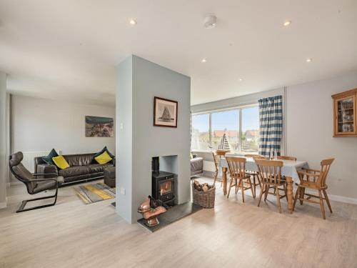 a living room with a fireplace and a dining room at Little Dab in Brancaster
