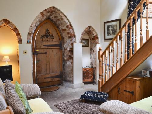 a living room with a large wooden door and stairs at The Low Lodge in Hunmanby