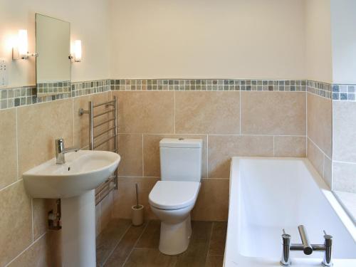 a bathroom with a toilet and a sink and a bath tub at Hovera in Glenridding