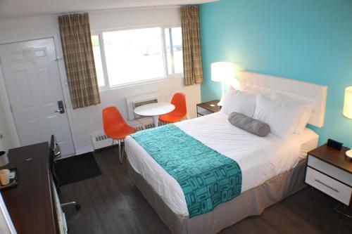 a hotel room with a bed and a table and chairs at Howard Johnson Inn by Wyndham Kingston in Kingston