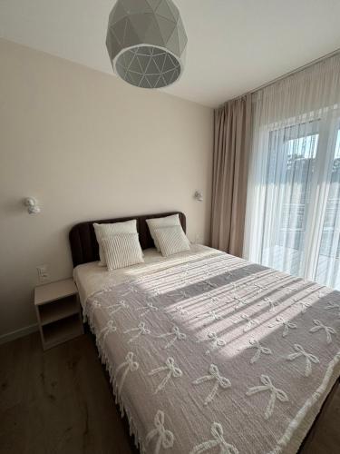 a bedroom with a large bed with a large window at Czarna Perła Hel in Hel
