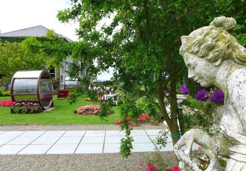 a statue of a woman in a garden with flowers at Tinakilly Country House Hotel in Rathnew