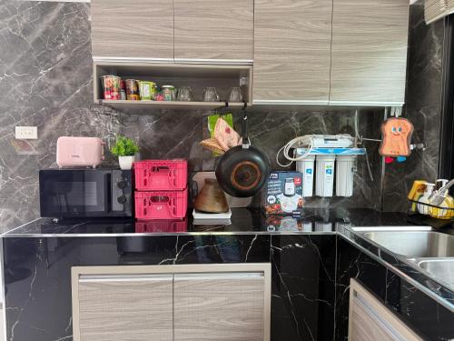 a kitchen with a counter top with a red microwave at เพชรกล้าพูลวิลล่า in Ban Noi