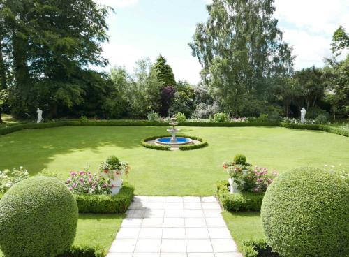 a garden with a fountain in the middle of a lawn at Tinakilly Country House Hotel in Rathnew