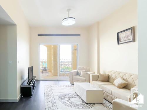 a living room with a couch and a tv at 1BR Getaway in RAK l Balcony , Pool and Gym Access in Ras al Khaimah